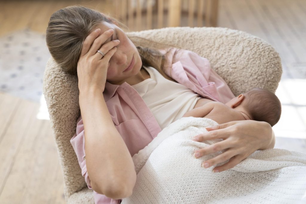 Mujer con depresion posparto cuidando a su bebé