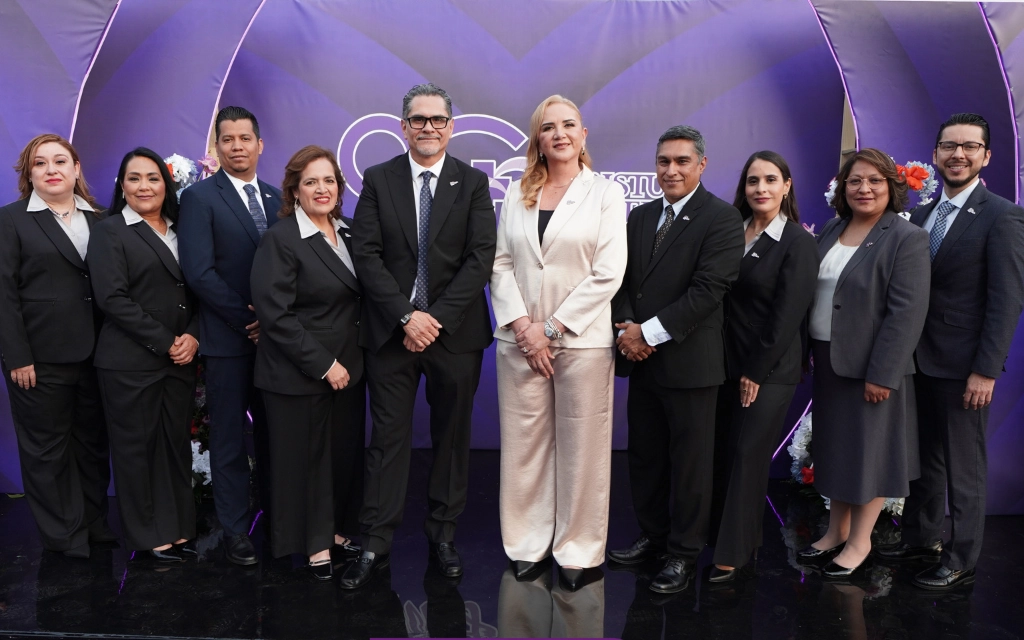 Un grupo de personas frente a un fondo morado mirando a la cámara
