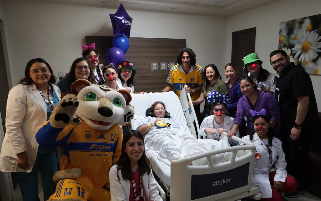 Voluntarios sonríen mientras visitan a un paciente